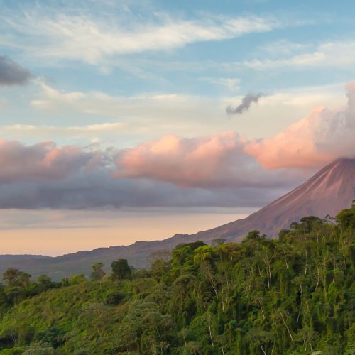 Arenal Volcano at Sunrise in Costa Rica, as the sun reflects on the newly formed clouds