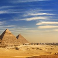 Egypt. Cairo - Giza. General view of pyramids and cityskape from the Giza Plateau (on front side: three pyramids popularly known as Queens' Pyramids; next in order from left: the Pyramid of Menkaure /Mykerinos/, Khafre /Chephren/ and Chufu /Cheops/ - known as the Great Pyramid). The Pyramid Fields from Giza to Dahshur is on UNESCO World Heritage List