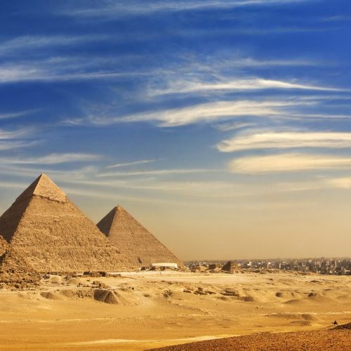 Egypt. Cairo - Giza. General view of pyramids and cityskape from the Giza Plateau (on front side: three pyramids popularly known as Queens' Pyramids; next in order from left: the Pyramid of Menkaure /Mykerinos/, Khafre /Chephren/ and Chufu /Cheops/ - known as the Great Pyramid). The Pyramid Fields from Giza to Dahshur is on UNESCO World Heritage List